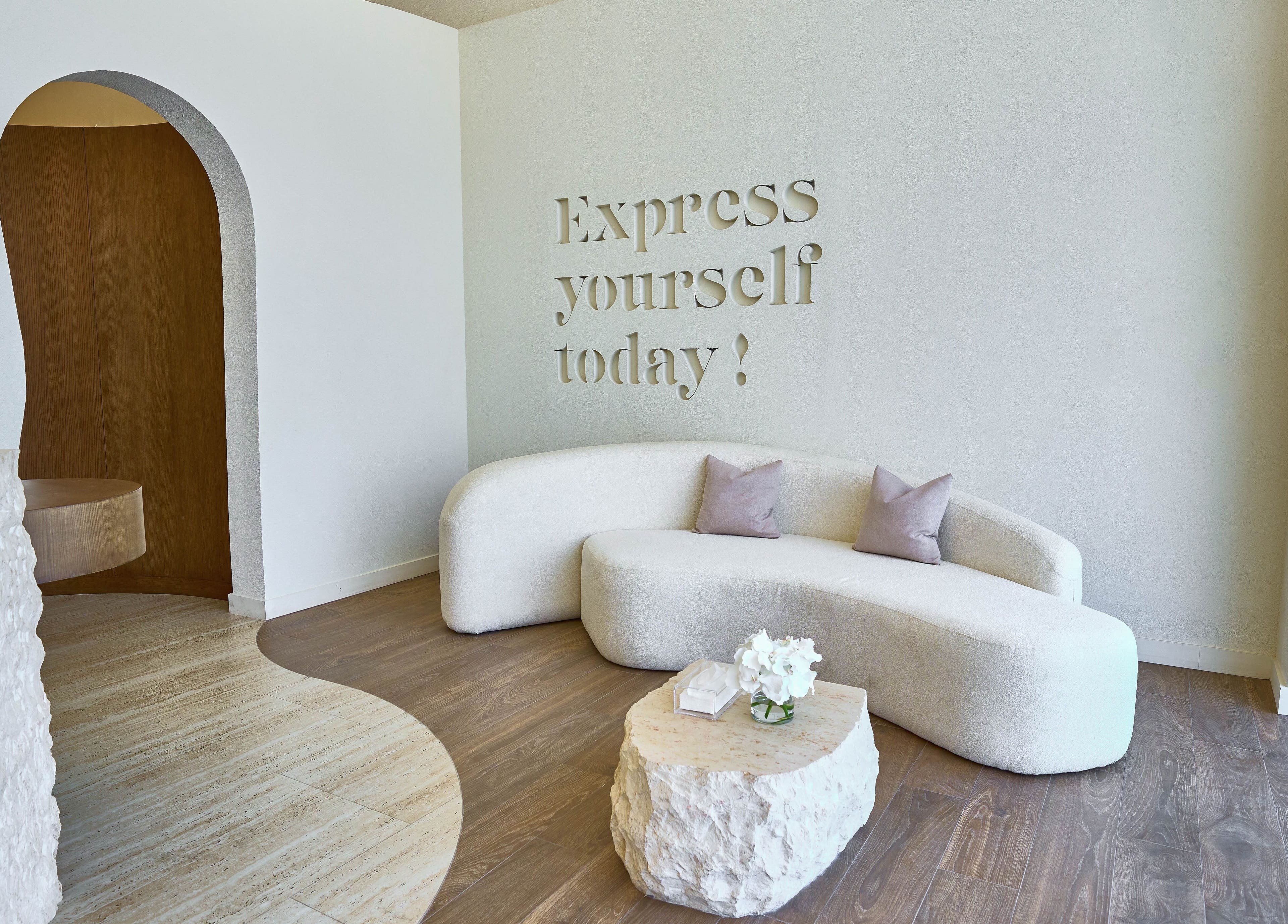 Modern seating area at Obar Beauty, Riyadh, Riyadh Province, SA featuring a curved sofa and inspirational decor.