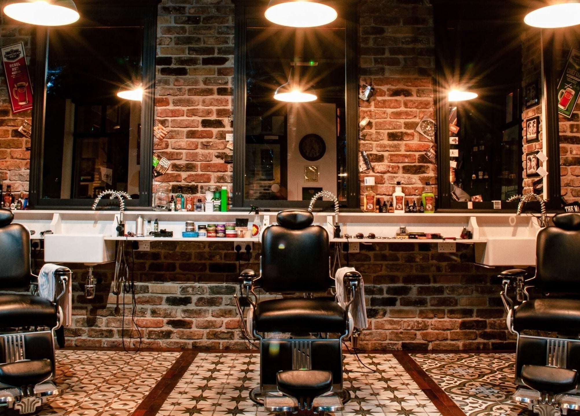 Interior of Masters Barbershop in Alpharetta, Georgia, US featuring classic black barber chairs and brick walls.