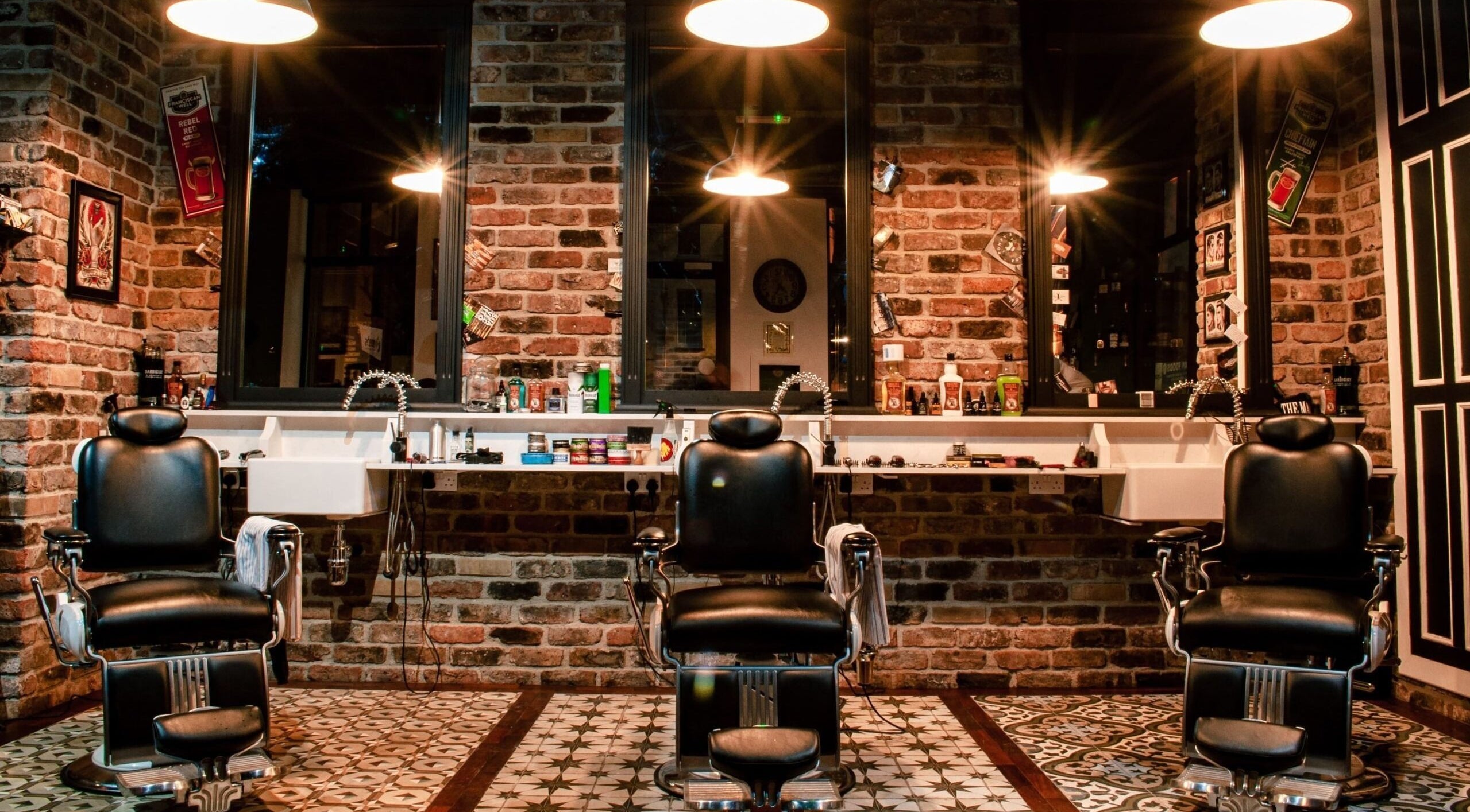 Interior of Masters Barbershop in Alpharetta, Georgia, US featuring classic black barber chairs and brick walls.