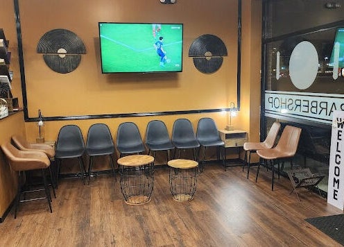 Welcoming seating area at Masters Barbershop in Alpharetta, Georgia, US with modern chairs and warm lighting.