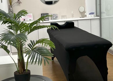 Sala de tratamento em Elitania Oliveira Beauty Expertise, Algueirão-Mem Martins, Lisboa, PT com mesa e planta.