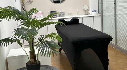 Sala de tratamento em Elitania Oliveira Beauty Expertise, Algueirão-Mem Martins, Lisboa, PT com mesa e planta.