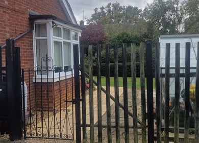 Entrance gate at Wilmslow Avenue, Woodbridge, showing a charming garden setting in Woodbridge, England, GB.
