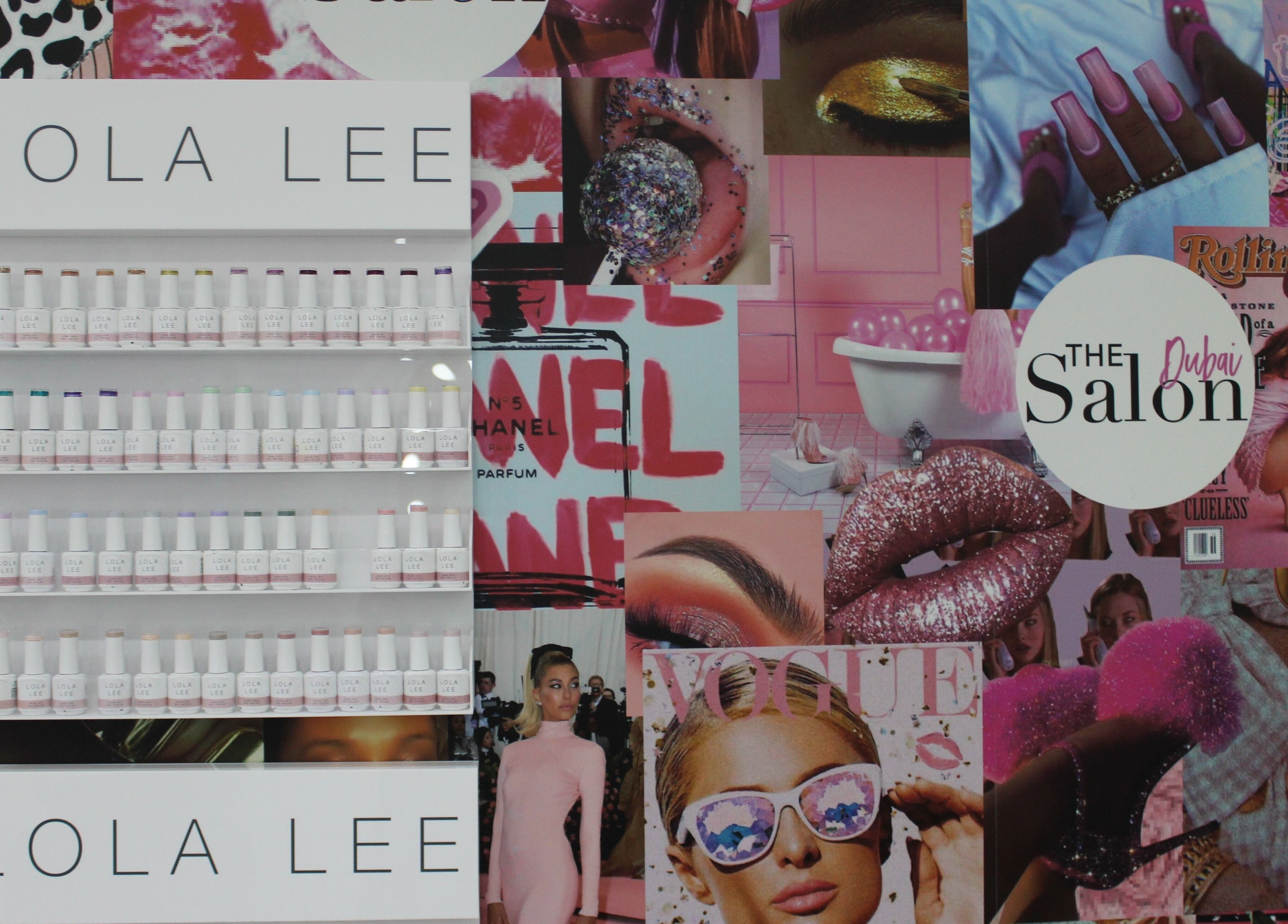 Colorful nail polish display at The Salon at Yin Yang JBR, Dubai, AE with a vibrant wall collage.