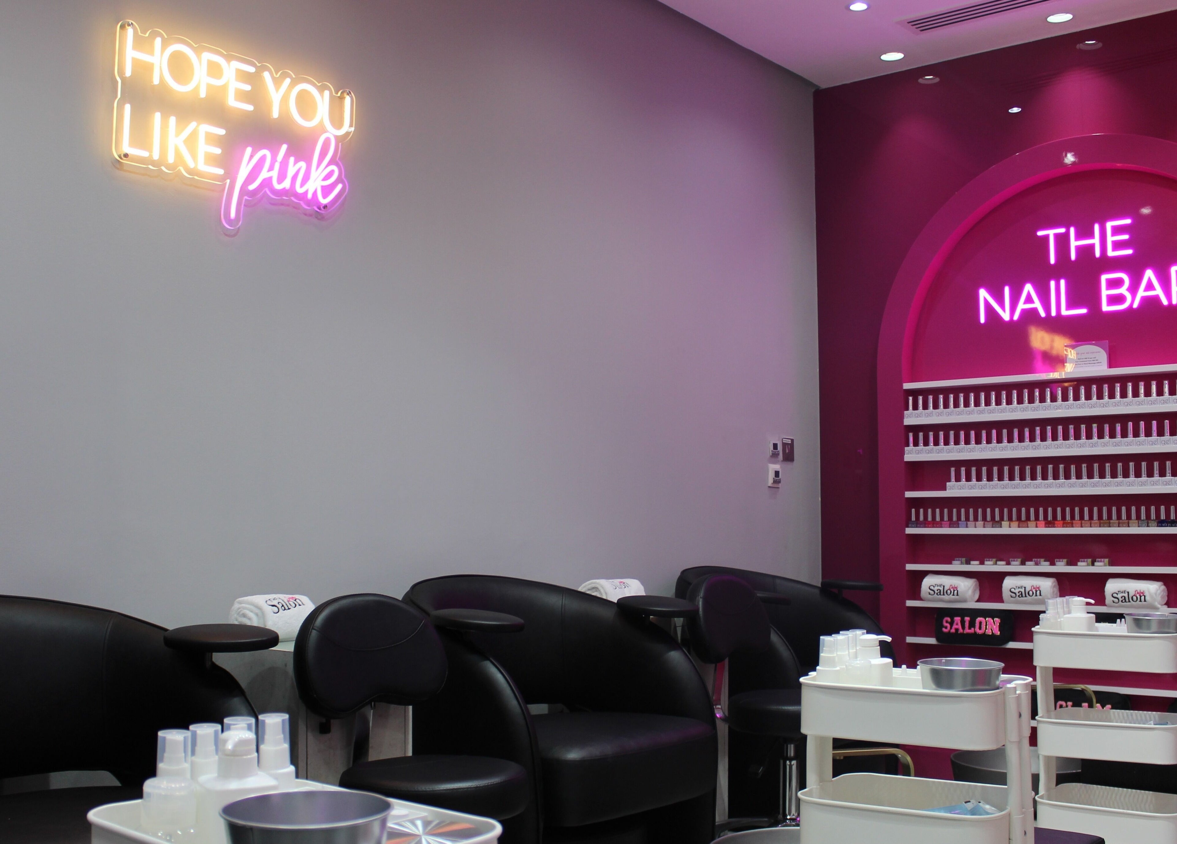 The Salon at Ocean View Hotel JBR, Dubai, AE features chic pink nail bar with neon lights and modern seating.