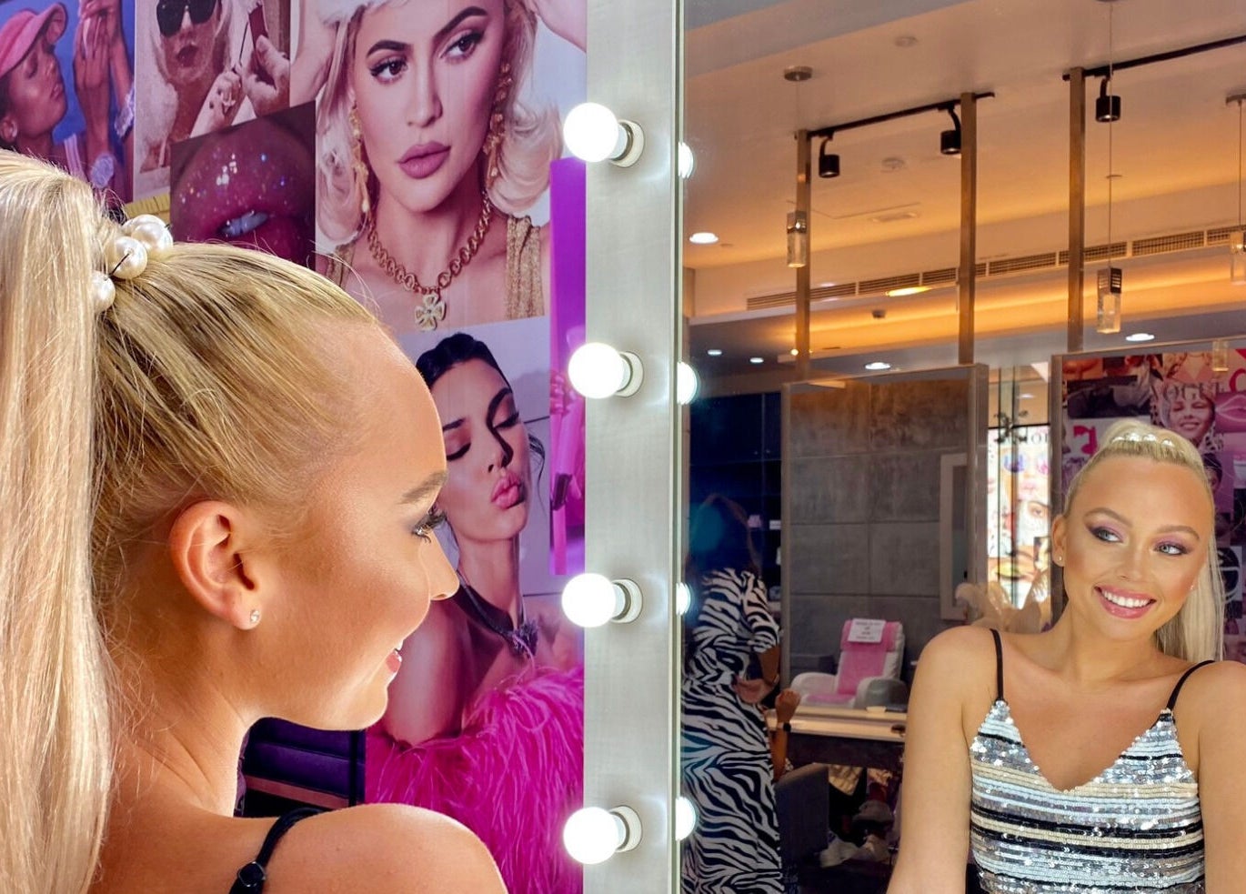 Woman admires her hairstyle in mirror at The Salon at Yin Yang Al Wasl, Dubai, AE, surrounded by glam decor.
