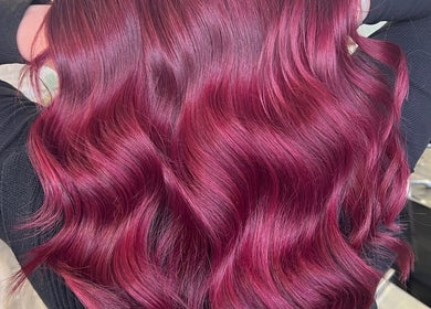 Vibrant crimson hair waves at Poppy Harrison Hair, Blackpool, England, GB showcasing rich color and shine.