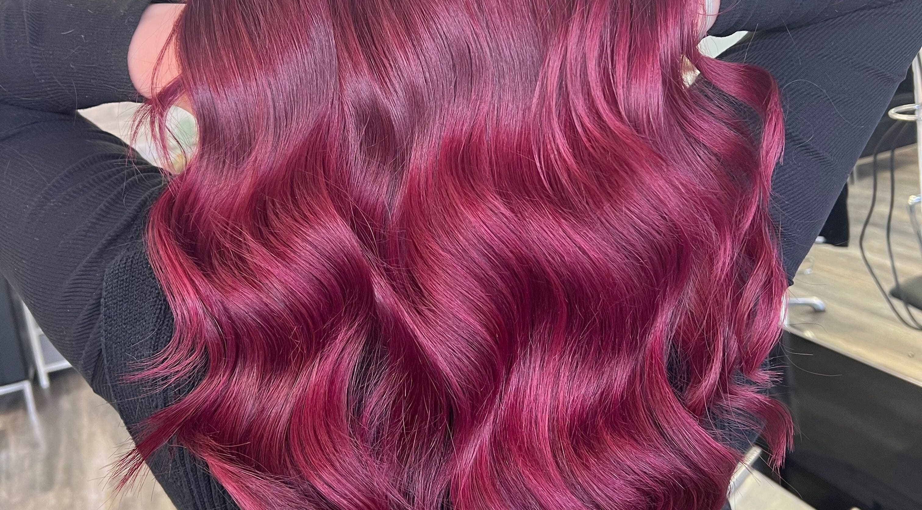 Vibrant crimson hair waves at Poppy Harrison Hair, Blackpool, England, GB showcasing rich color and shine.