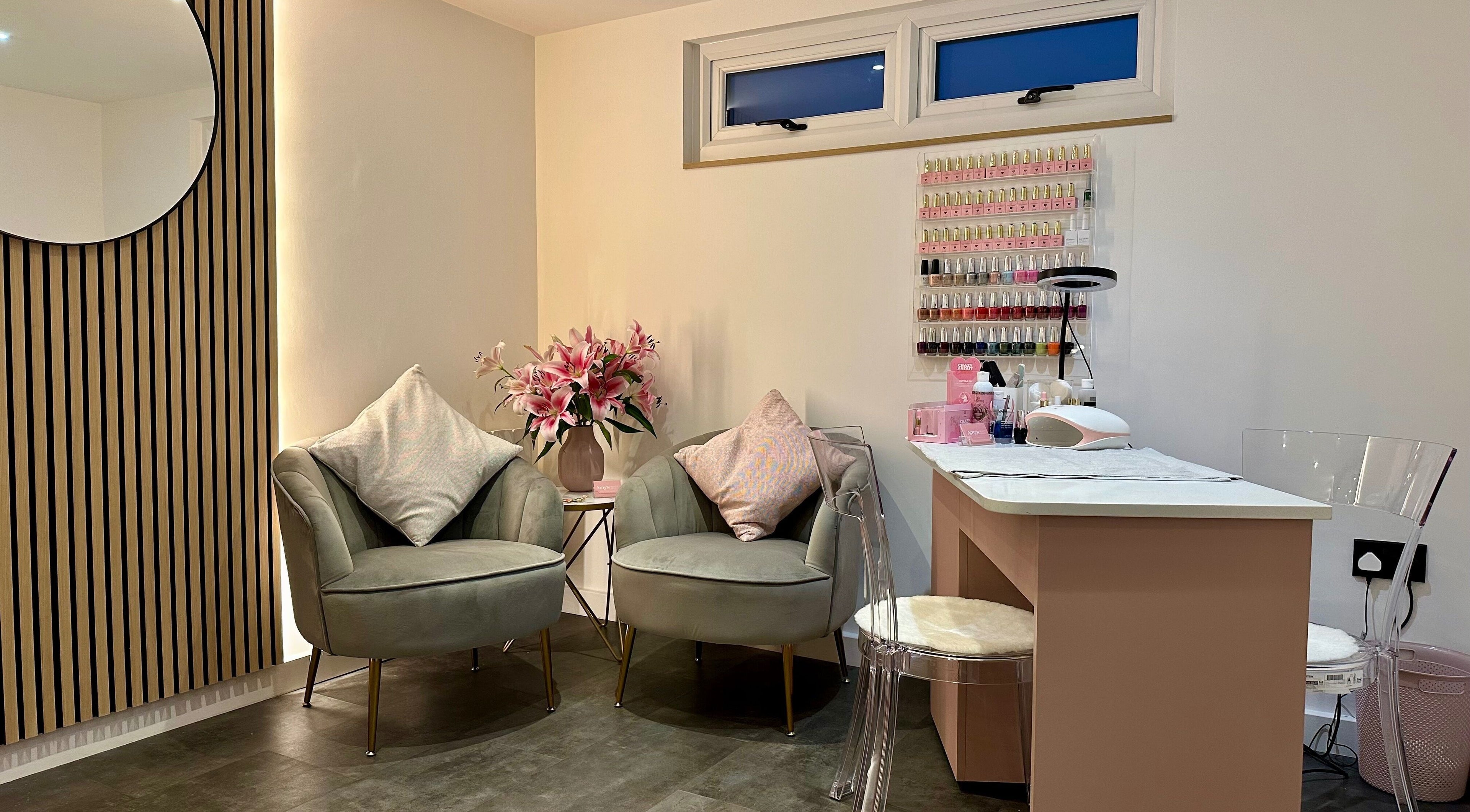 Elegant seating area and nail station at Amy’s Beauty Room, Cullompton, England, GB, showcasing modern decor.
