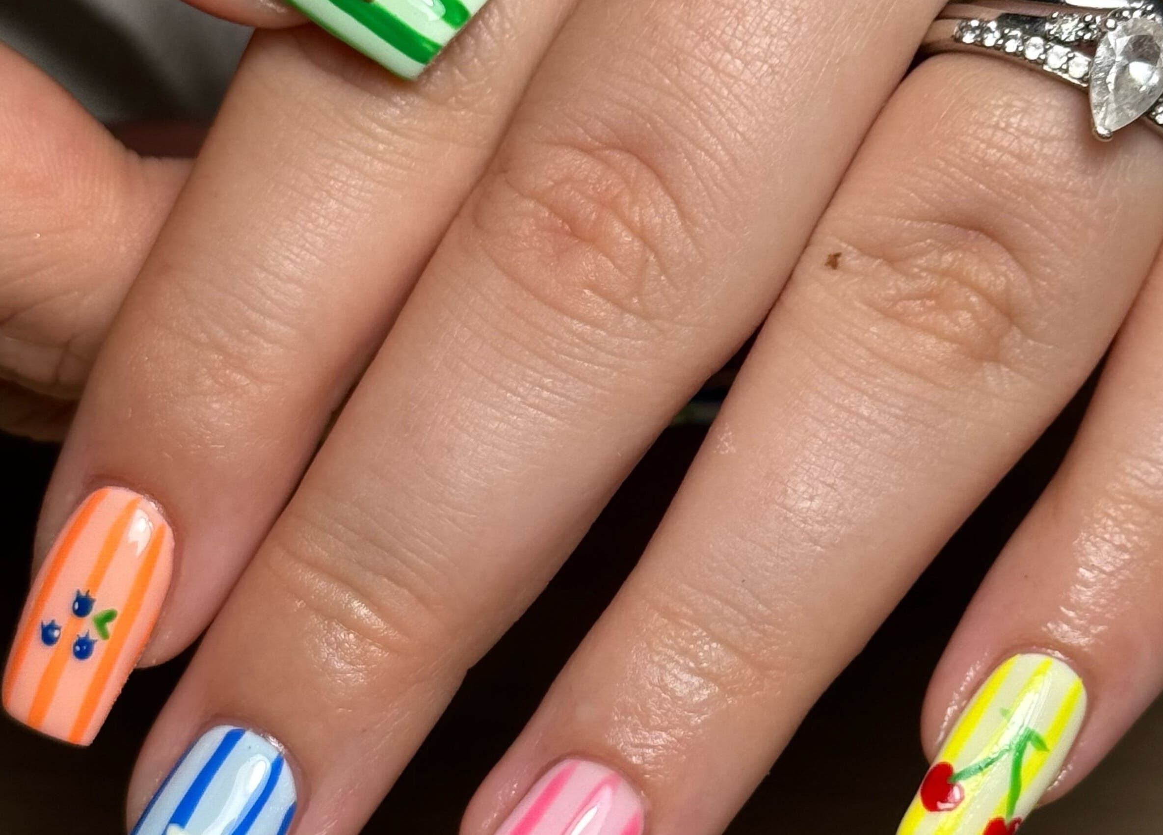 Colorful nail art showcasing fruity designs at BY.M.R.B, Colchester, England, GB.