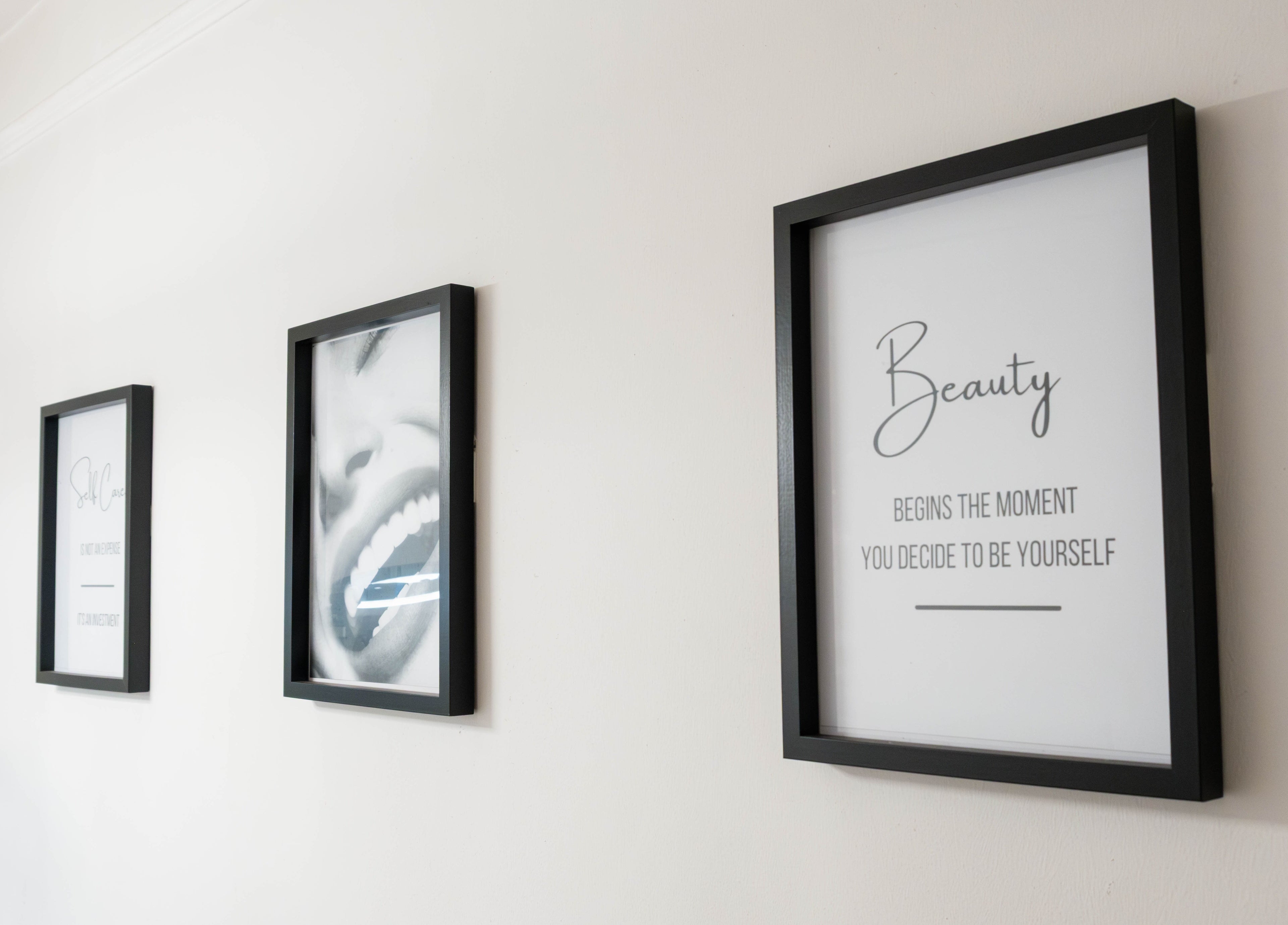 Decorative framed quotes on a wall at Jeta Brows, London, England, GB creating an inspiring atmosphere.