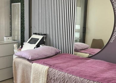 Sala de tratamiento en KineMilagros Cl, Santiago, Región Metropolitana, CL con camas y decoración acogedora.