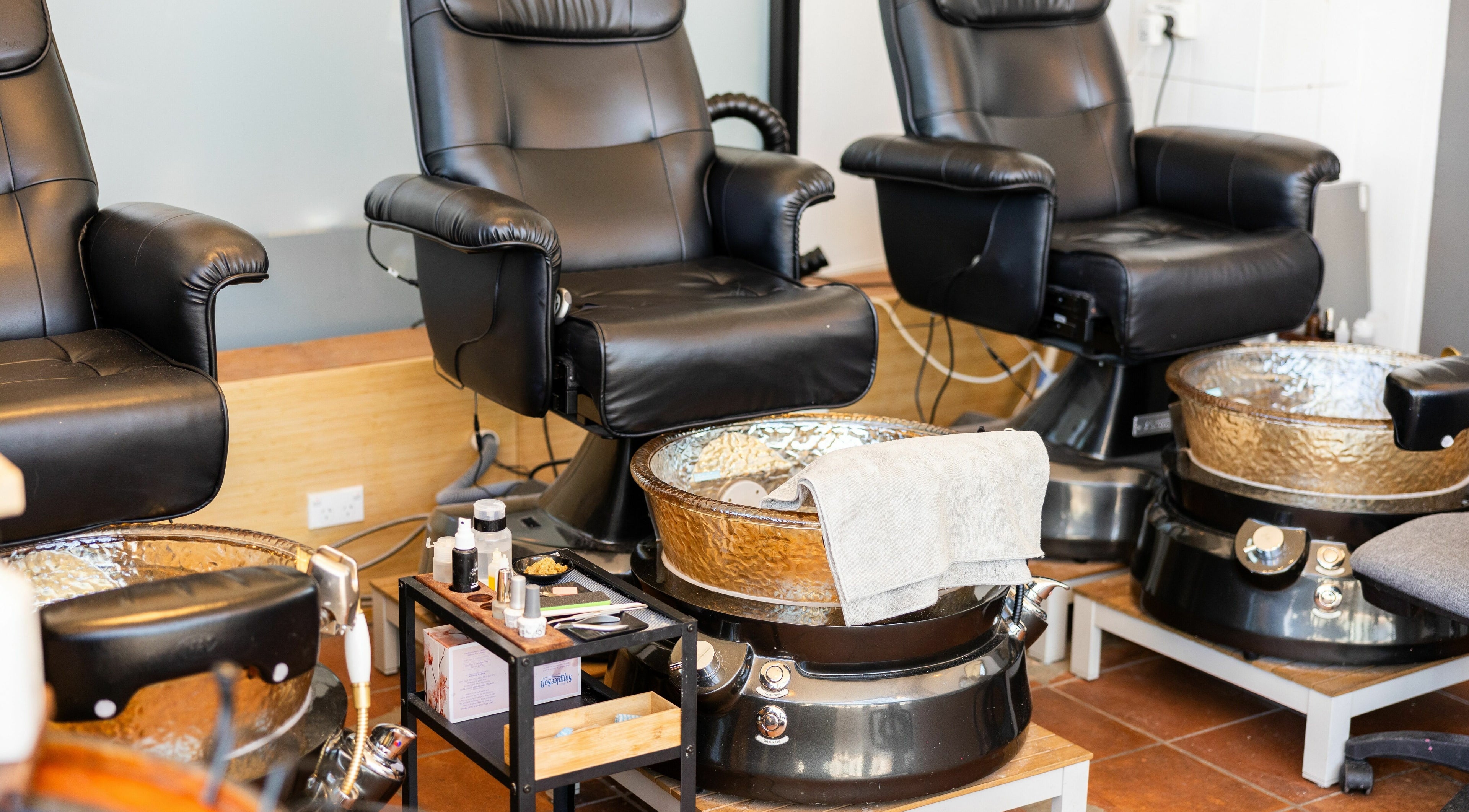 Luxurious pedicure stations at La Coeur - Rosebery in Rosebery, New South Wales, AU. Comfortable black chairs and spa bowls.