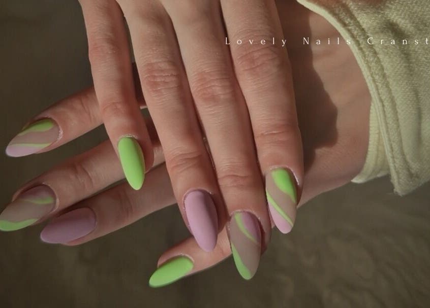 Colorful nail art with green and purple designs at Lovely Nails Spa, Cranston, Rhode Island, US.