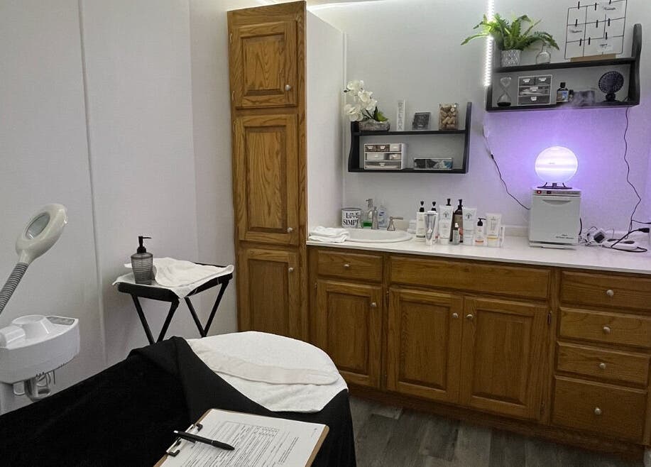 Calm treatment room at Timeless Beauty Bar LLC, Chillicothe, Missouri, US, showcasing wooden cabinets and spa equipment.