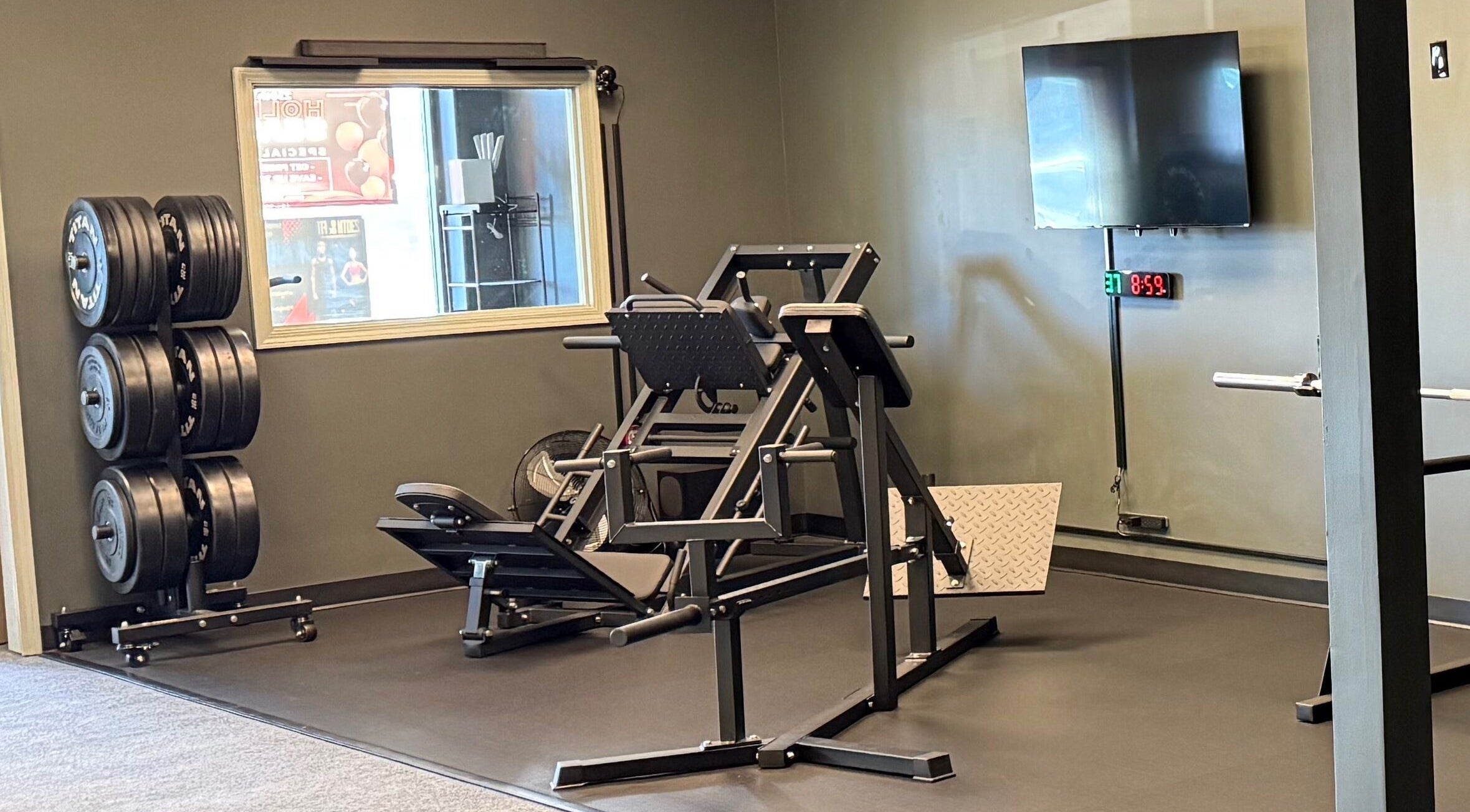 Fitness equipment at TNT Personal Training Studio in Duluth, Georgia, US, featuring weights and a leg press machine.