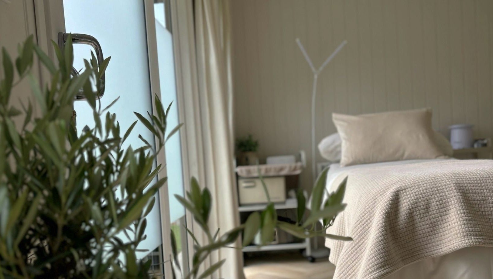 Relaxing treatment room at Tŷ Harddwch in Boduan, Wales, GB, featuring a cozy bed and soft lighting.