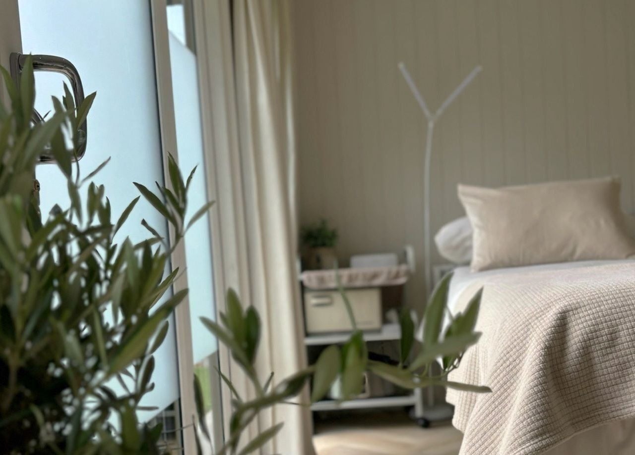 Relaxing treatment room at Tŷ Harddwch in Boduan, Wales, GB, featuring a cozy bed and soft lighting.
