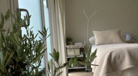 Relaxing treatment room at Tŷ Harddwch in Boduan, Wales, GB, featuring a cozy bed and soft lighting.
