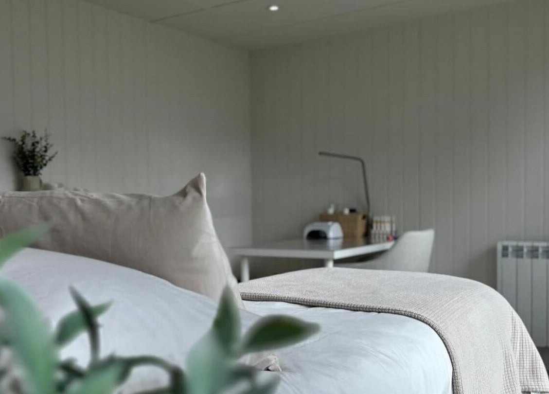 Calm therapy room at Tŷ Harddwch, Boduan, Wales, GB with soft pillows and a treatment table.