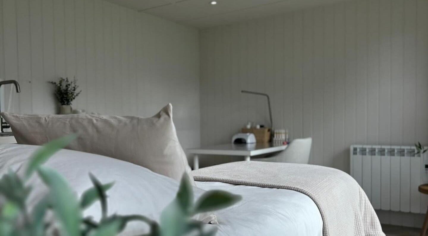 Calm therapy room at Tŷ Harddwch, Boduan, Wales, GB with soft pillows and a treatment table.