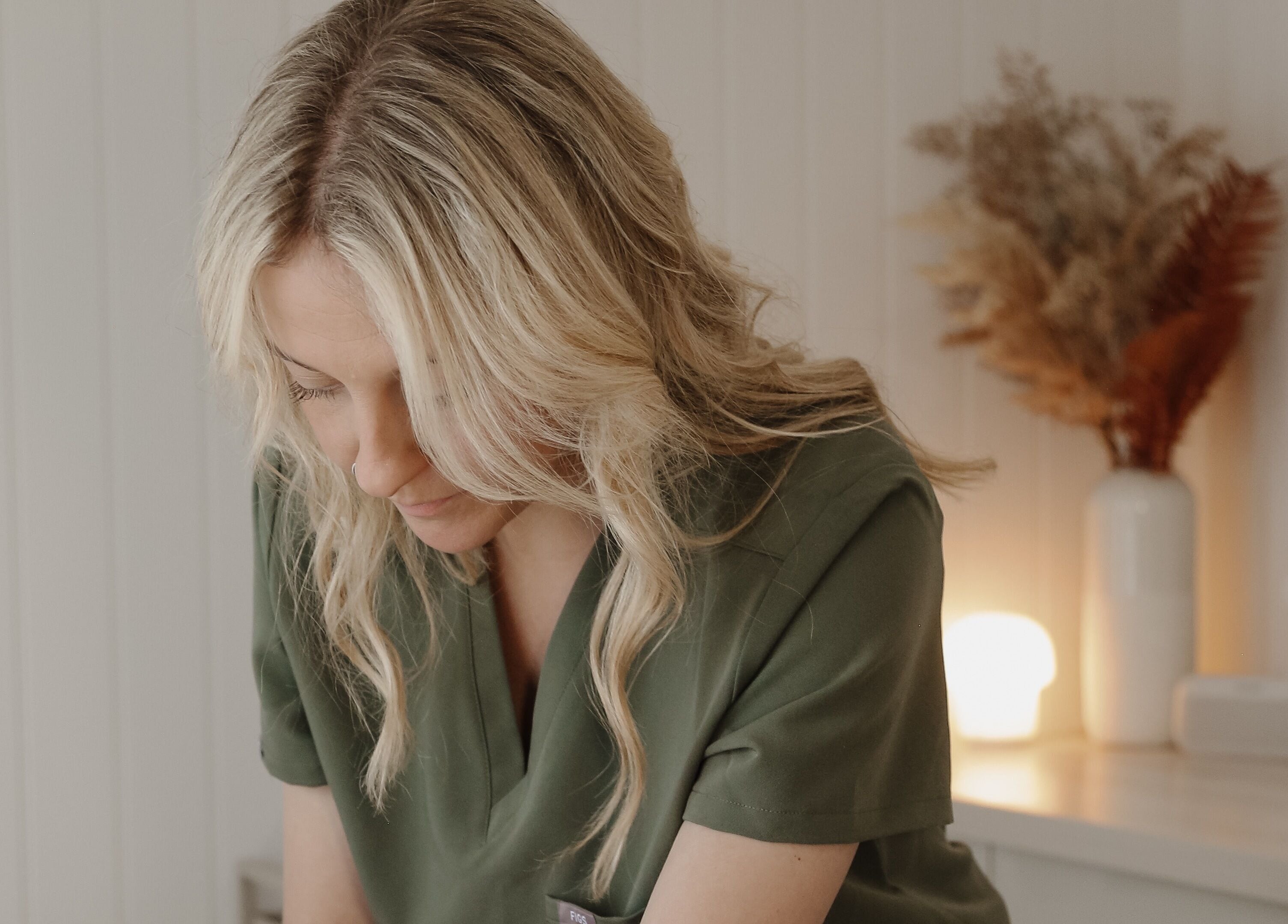 Beautician at Tŷ Harddwch, Boduan, Wales, provides a relaxing treatment in a serene setting.