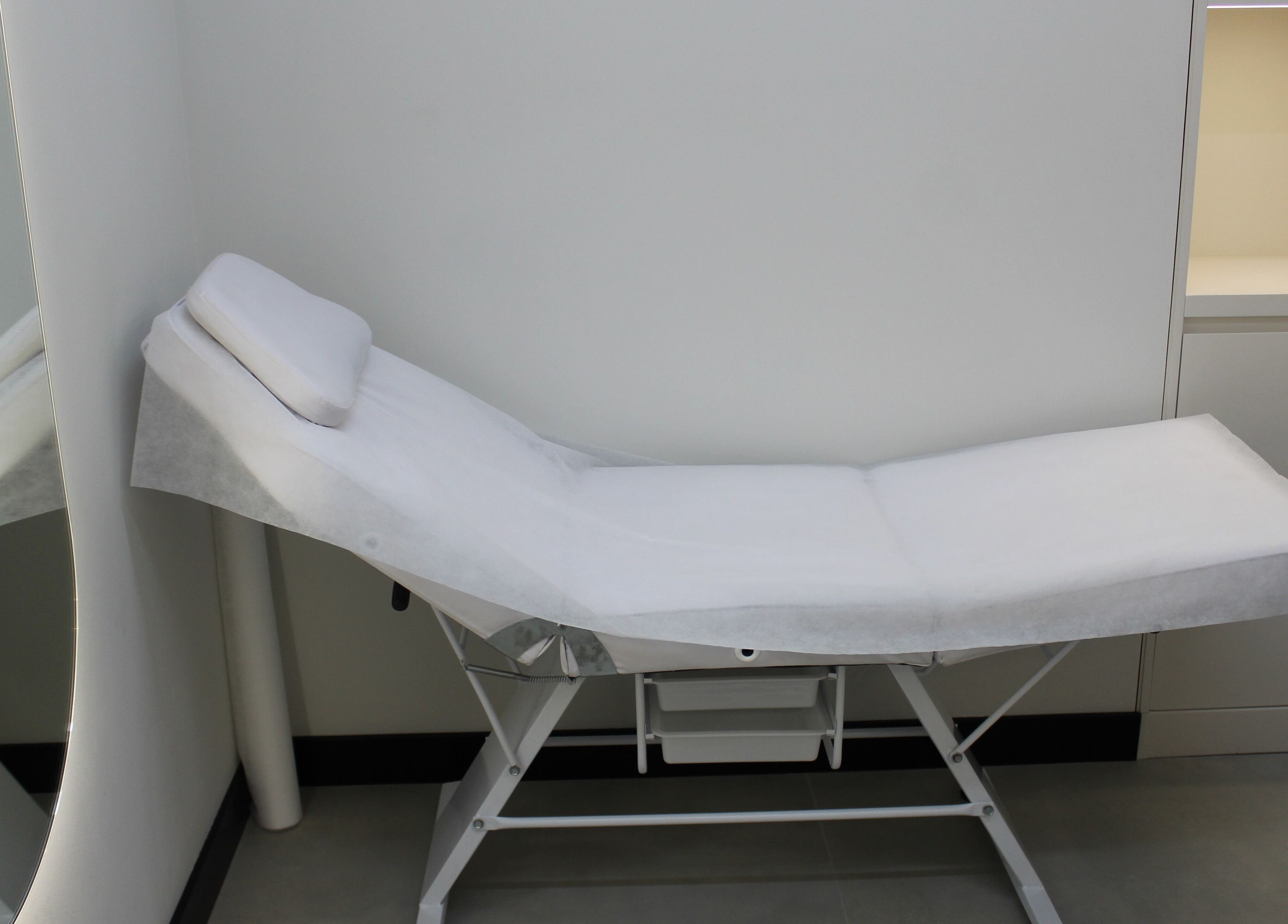 Comfortable treatment bed at Signature Piercing, Abu Dhabi, AE, offering a relaxing wellness experience.