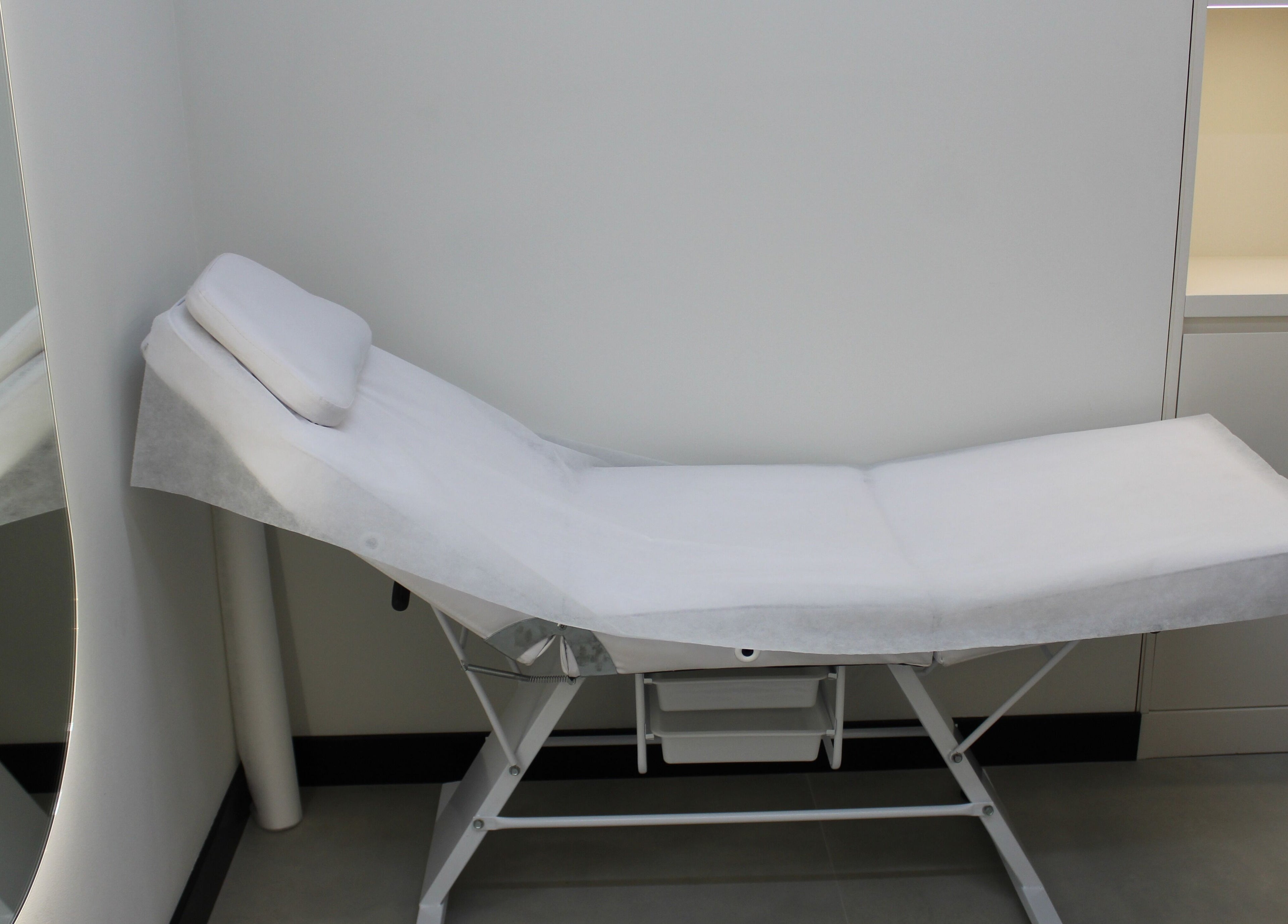 Comfortable treatment bed at Signature Piercing, Abu Dhabi, AE, offering a relaxing wellness experience.