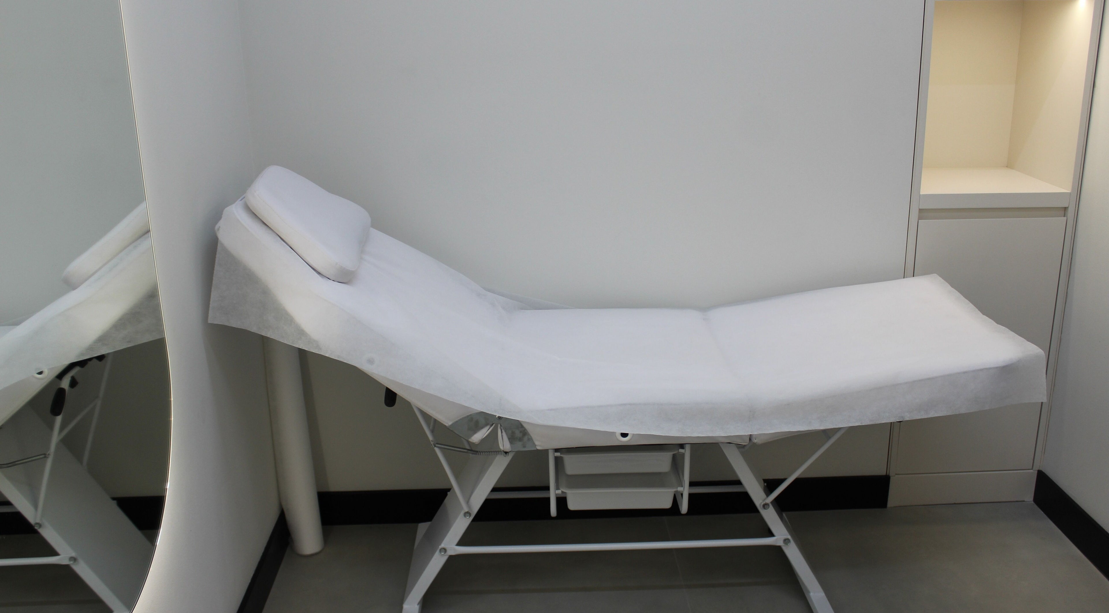 Comfortable treatment bed at Signature Piercing, Abu Dhabi, AE, offering a relaxing wellness experience.