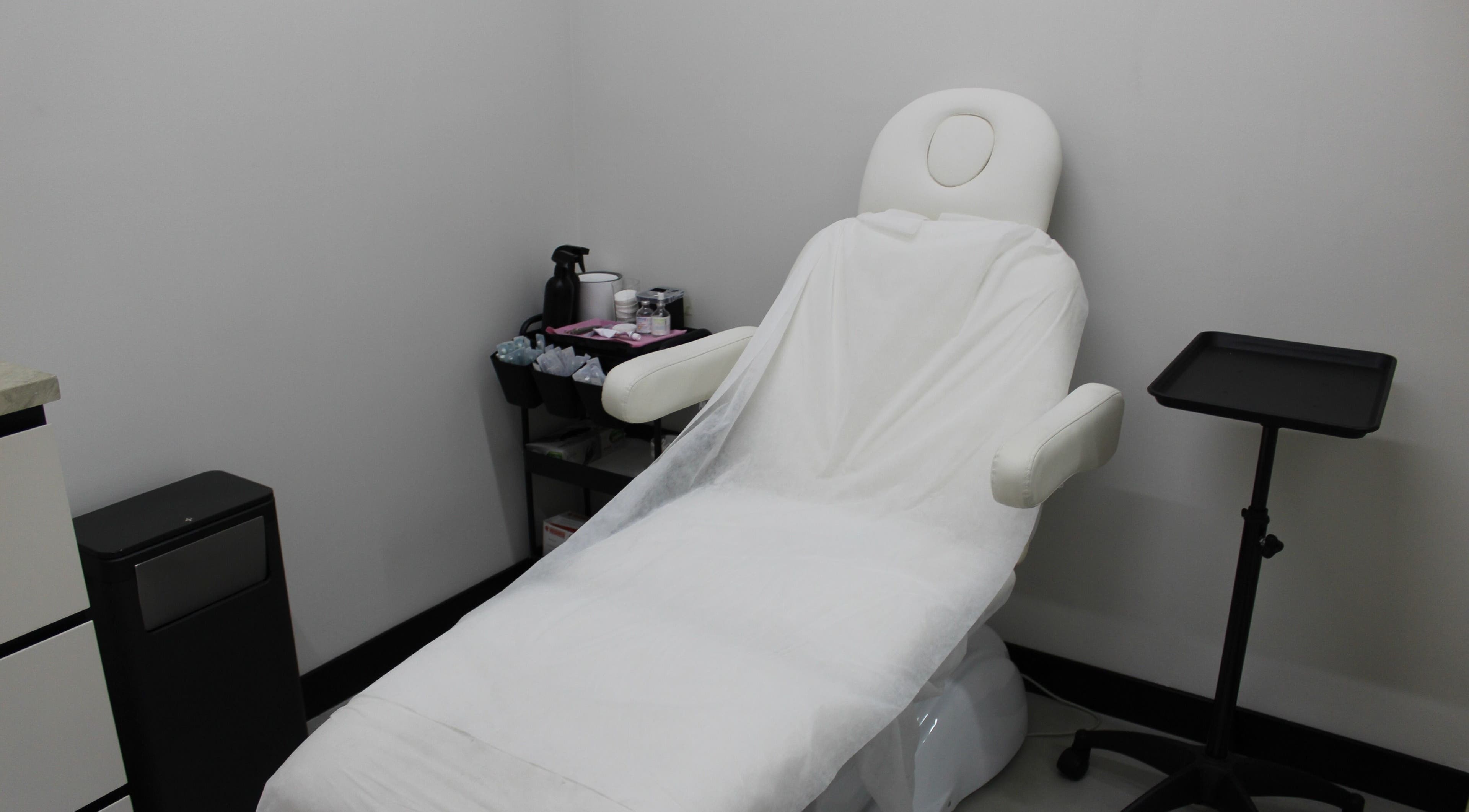 Relaxing treatment room at Signature Piercing, Abu Dhabi, AE, featuring a cozy chair and equipment.