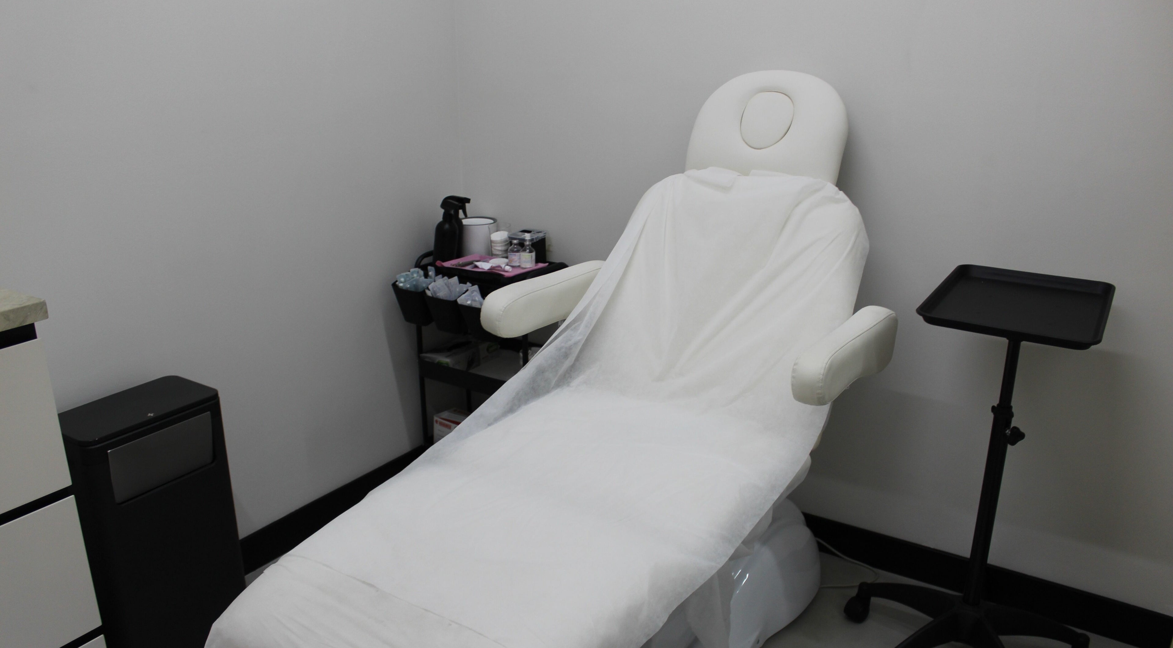 Relaxing treatment room at Signature Piercing, Abu Dhabi, AE, featuring a cozy chair and equipment.