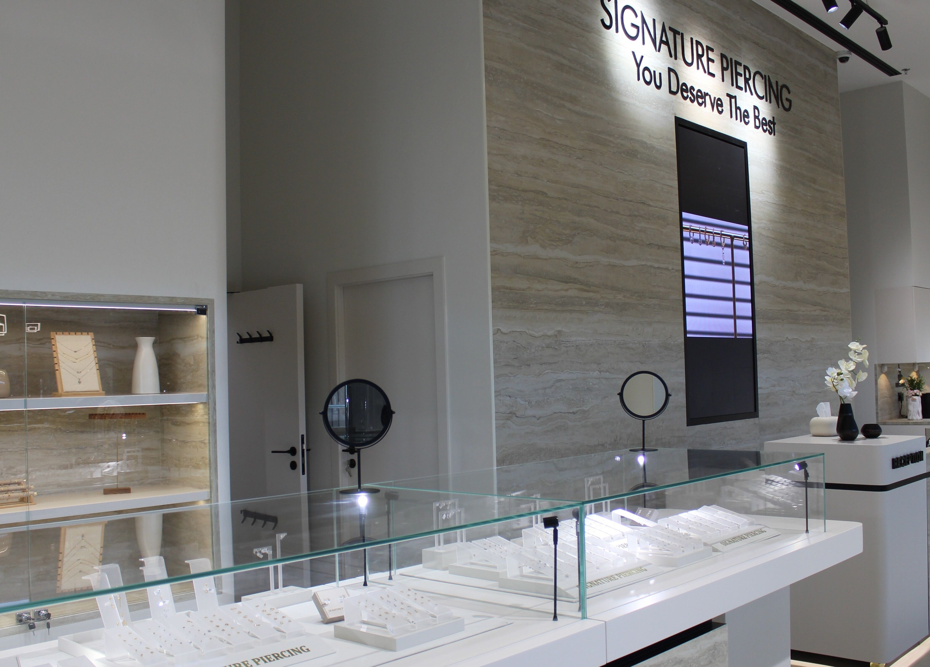Elegant interior of Signature Piercing in Abu Dhabi, AE, showcasing jewelry displays and modern decor.