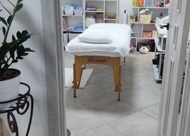 Спокійний масажний кабінет в ISA Massage, Бровари, UA з білим столом й рослиною.