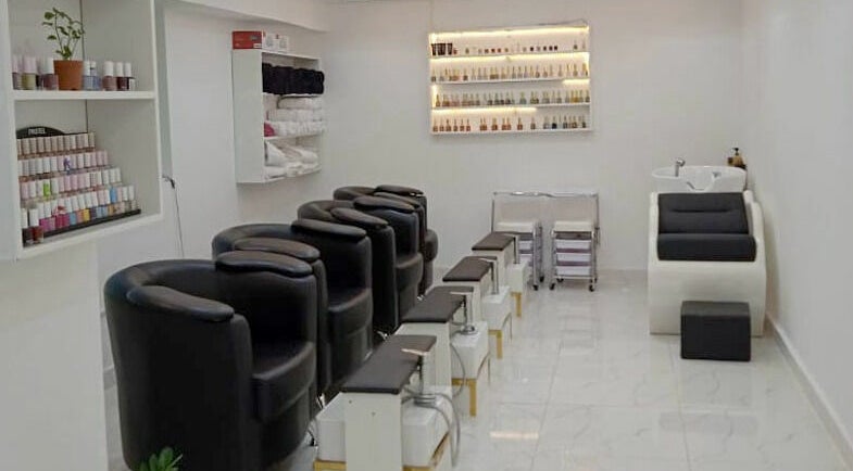 Chic nail salon area at Glamour Haven Beauty Center, Abu Dhabi, Abu Dhabi, AE, with black chairs and nail polish display.