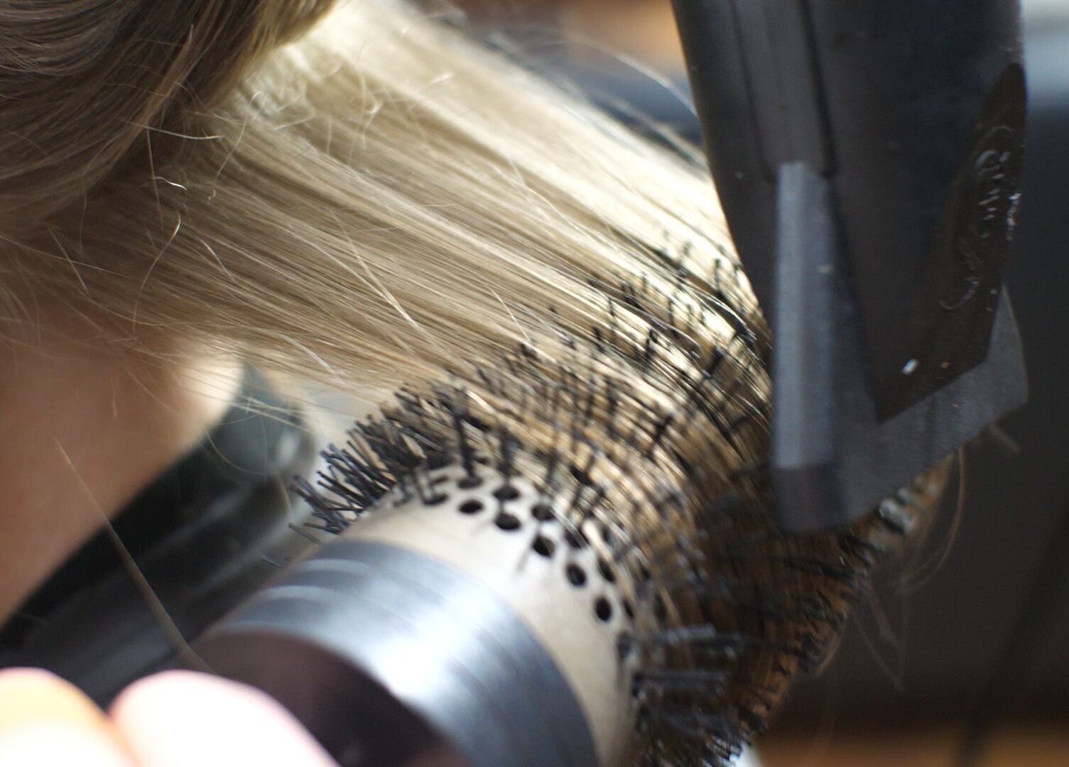 Hair styling at Alice Capriotti, Lavenham, England, GB with a blow dryer and brush close-up.