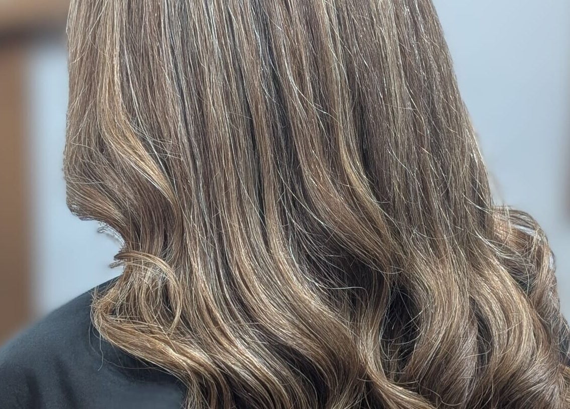 Elegant wavy hairstyle at Alice Capriotti in Lavenham, England, GB, showcasing silky brunette locks.