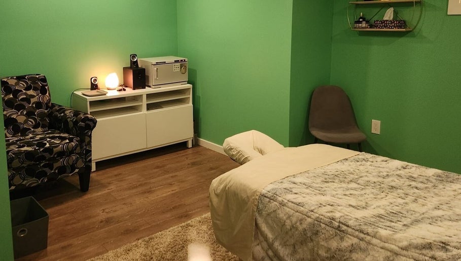 Cozy massage room at Massageopedia, Edmonton, Alberta, CA, with green walls and relaxing decor.