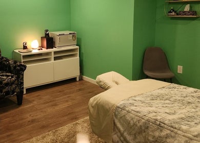 Cozy massage room at Massageopedia, Edmonton, Alberta, CA, with green walls and relaxing decor.