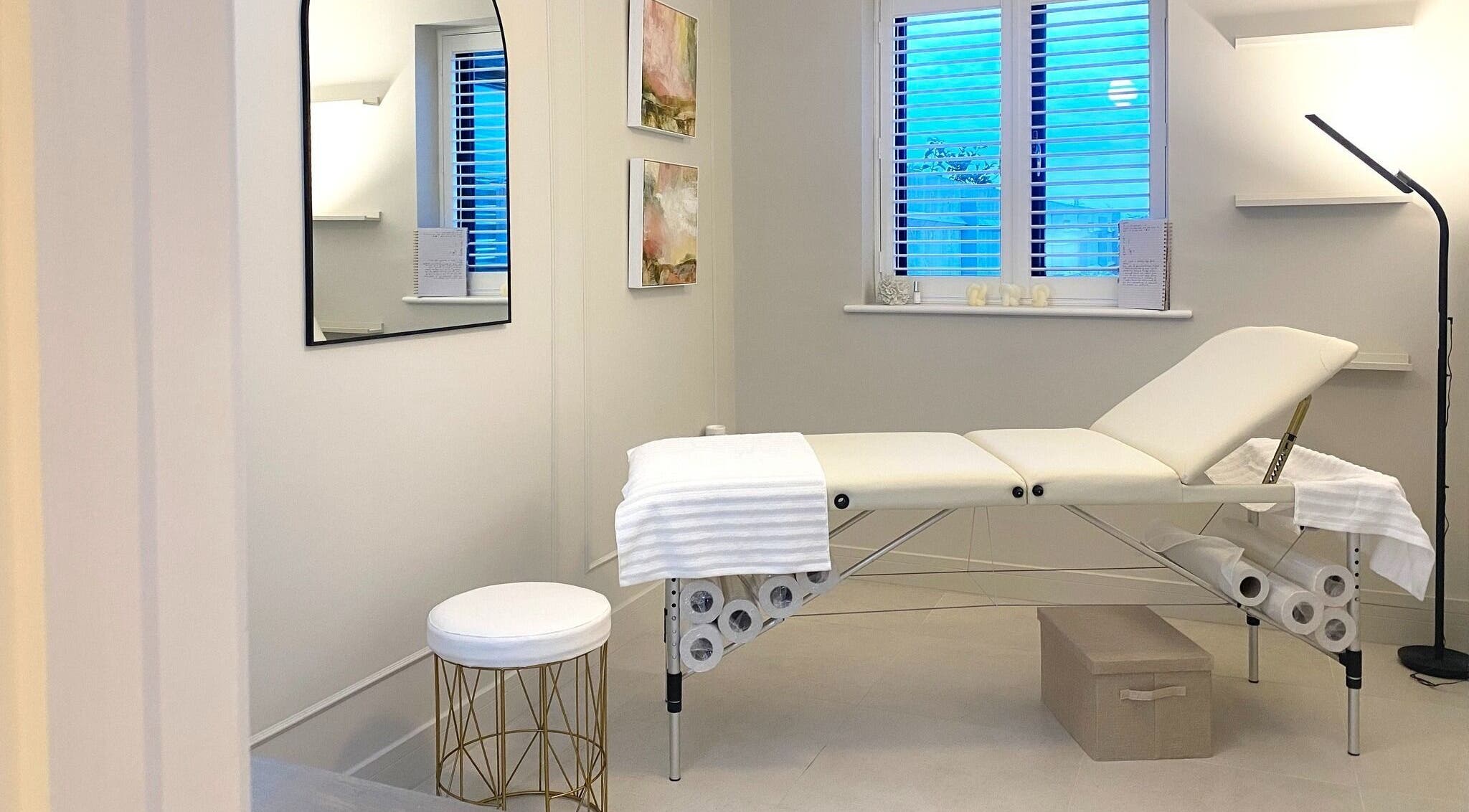 Calm treatment room at R Skin Aesthetics, Evesham, England, GB, with a cushioned bed and subtle decor.