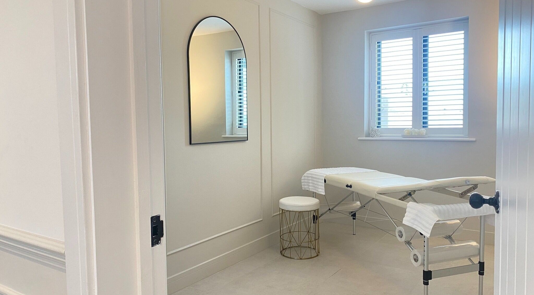 Tranquil treatment room at R Skin Aesthetics, Evesham, England, GB, showcasing a massage table under natural light.
