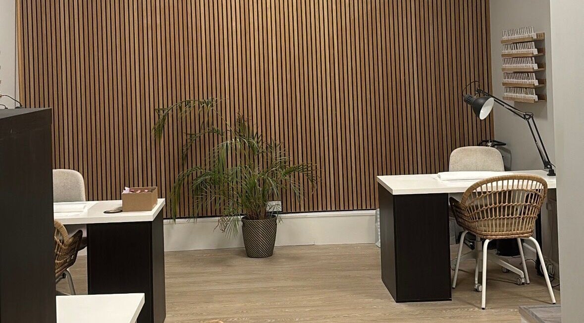 Modern manicure area at Megan May Studios, Mansfield, England, GB, featuring sleek desks and rattan chairs.
