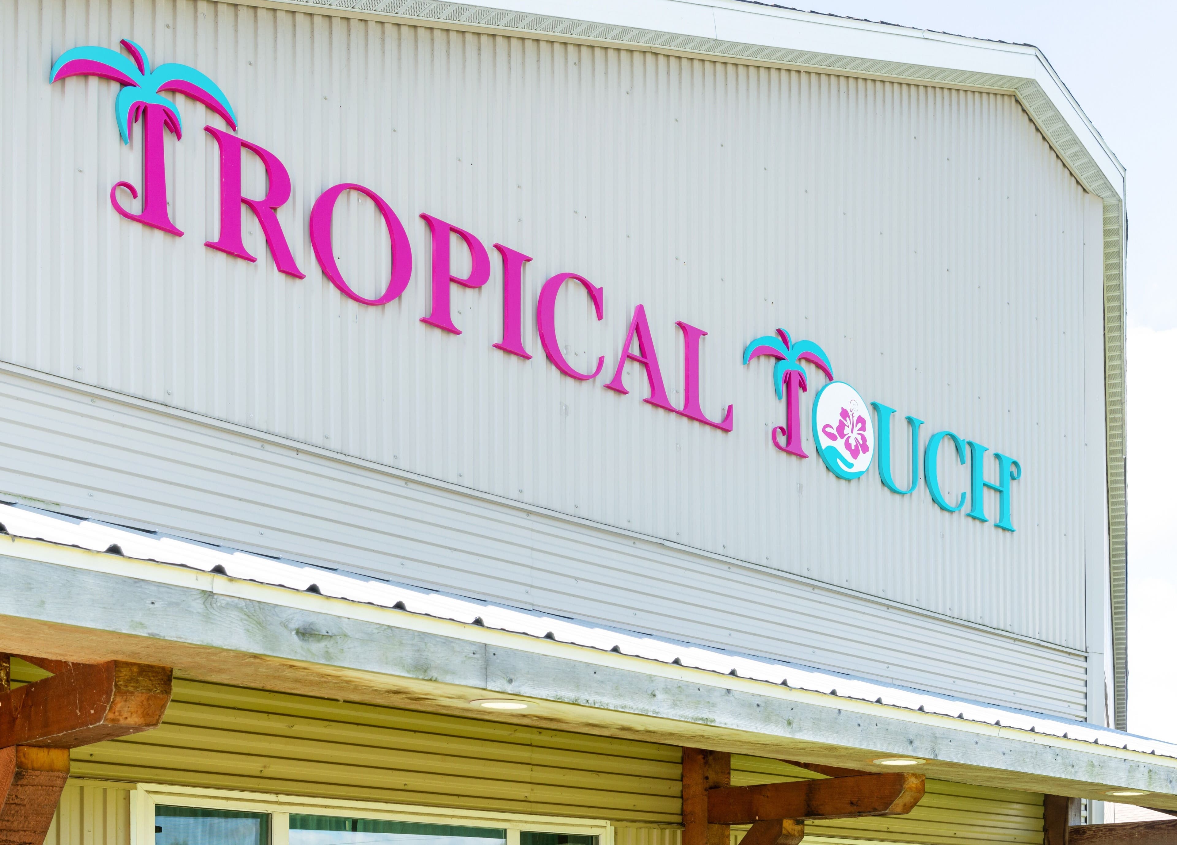 Entrance of Tropical Touch Spa in Jenison, Michigan, featuring vibrant signage and tropical design.