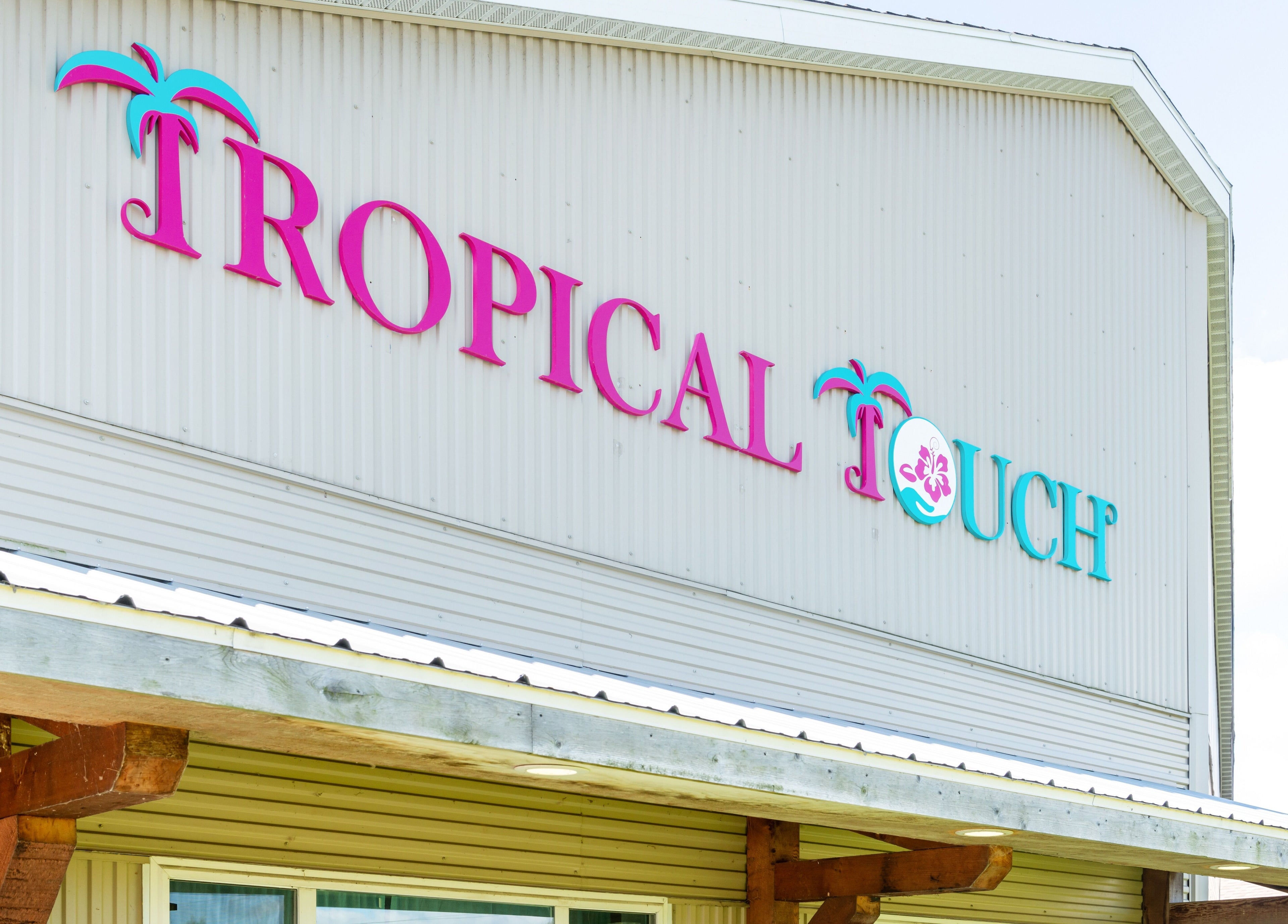 Entrance of Tropical Touch Spa in Jenison, Michigan, featuring vibrant signage and tropical design.