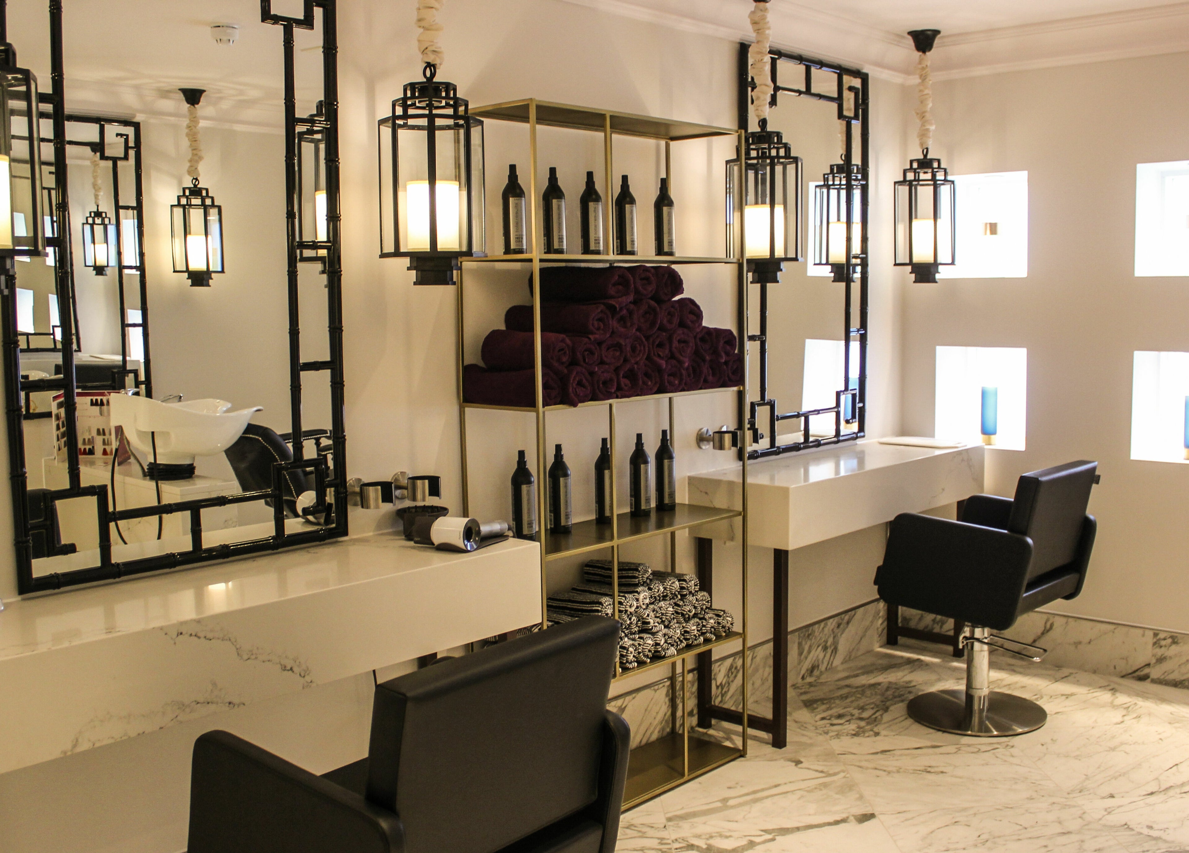 Luxurious salon area at The Hampton Spa, Failand, England, GB with stylish decor and modern styling chairs.