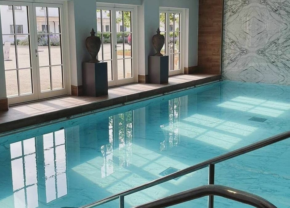 Indoor pool at The Hampton Spa, Failand, England, GB, with natural light streaming through windows.