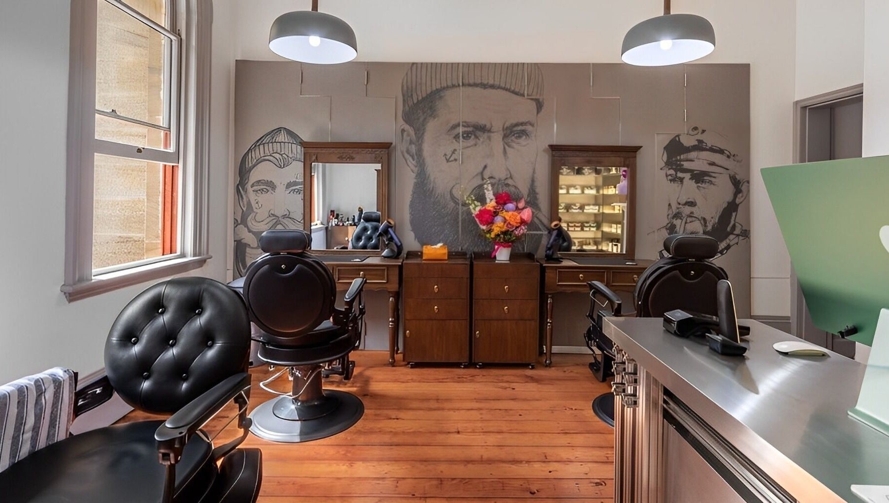 Interior of Uptown Barbers The Rocks in New South Wales, AU, featuring stylish chairs and artistic decor.