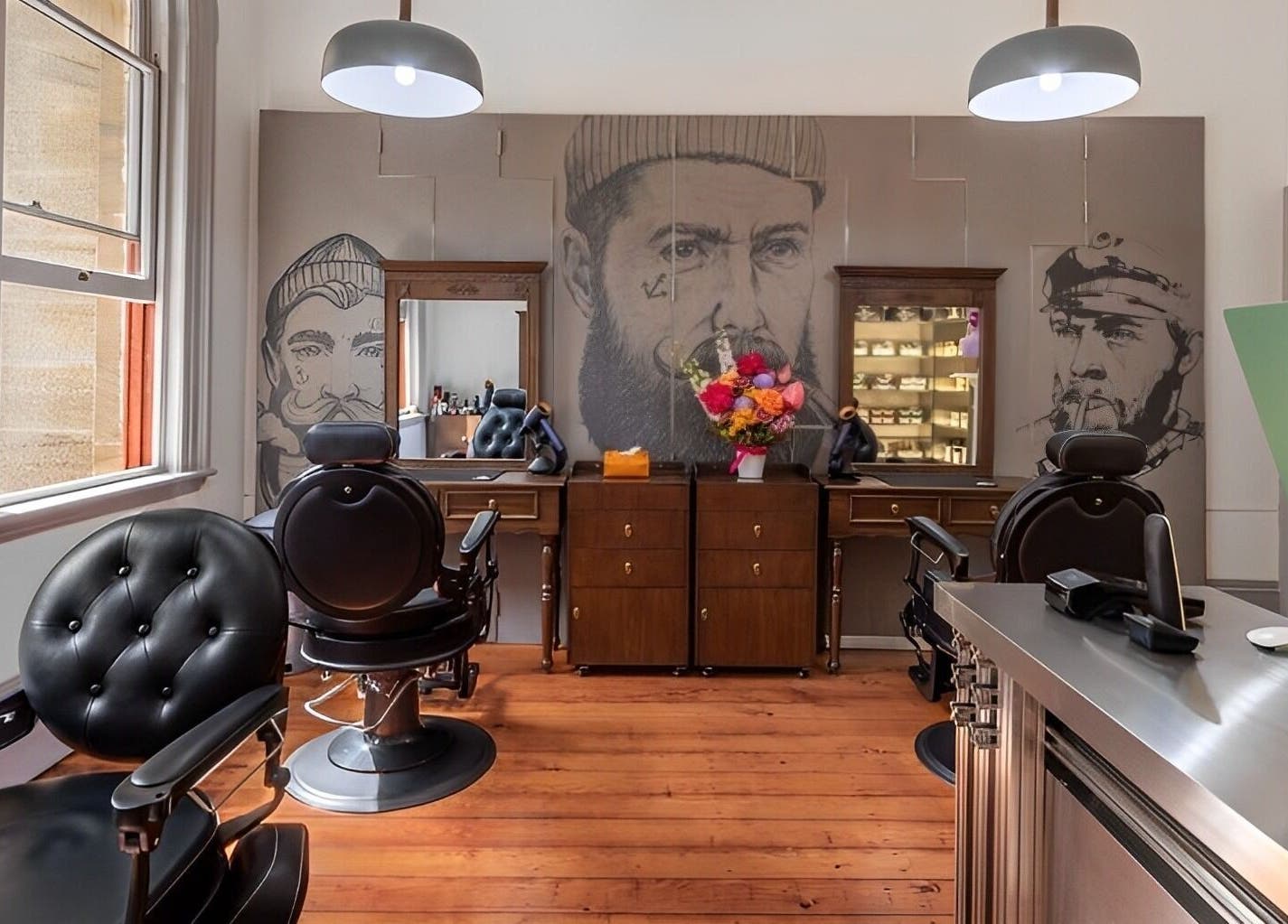 Interior of Uptown Barbers The Rocks in New South Wales, AU, featuring stylish chairs and artistic decor.