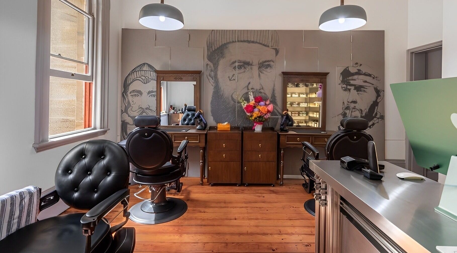 Interior of Uptown Barbers The Rocks in New South Wales, AU, featuring stylish chairs and artistic decor.