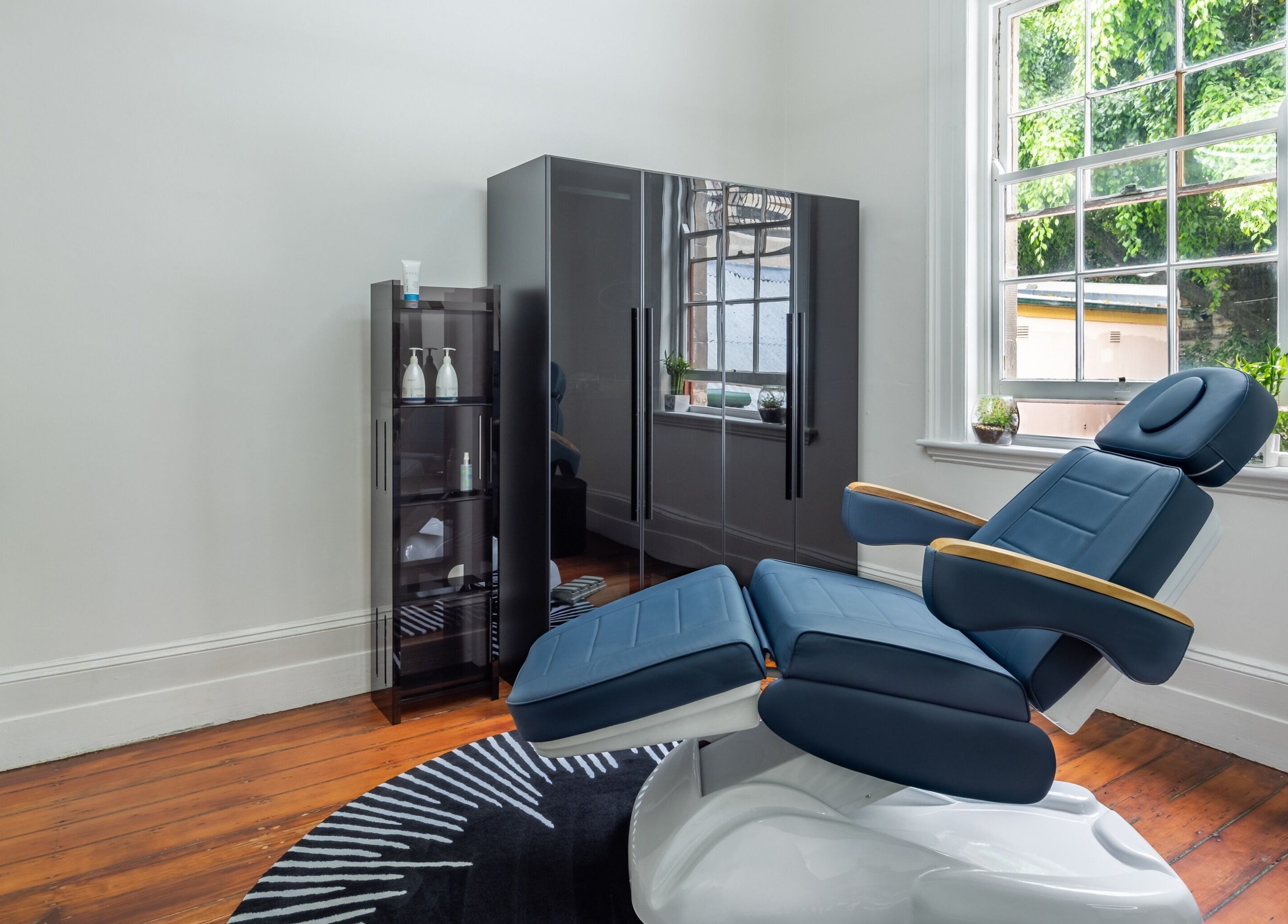 Relaxing barber chair at Uptown Barbers The Rocks, The Rocks, New South Wales, AU, near a large window.