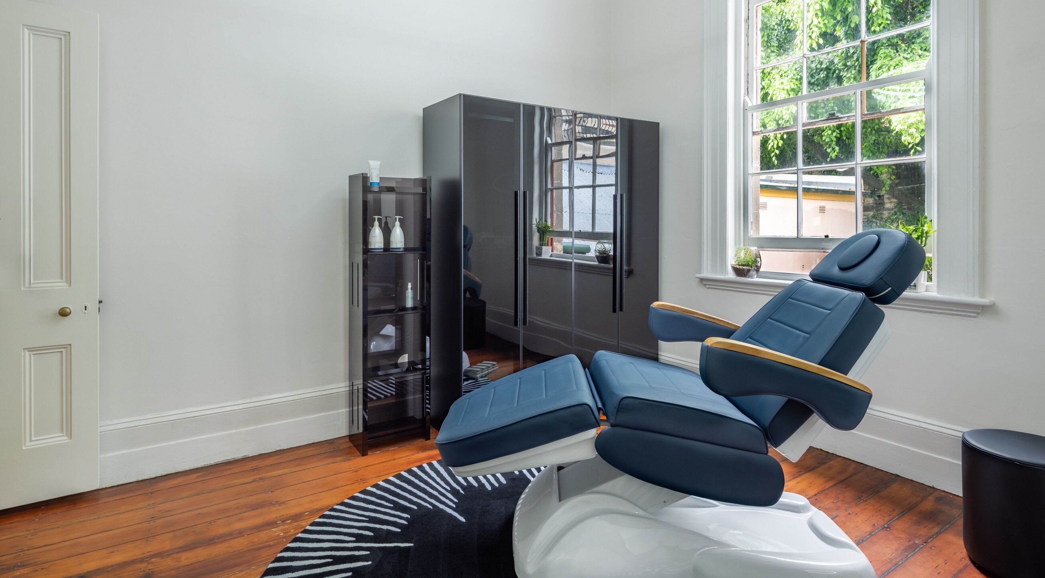 Relaxing barber chair at Uptown Barbers The Rocks, The Rocks, New South Wales, AU, near a large window.